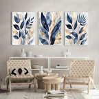 Three abstract leaf paintings above a living room setup with chairs and a coffee table.
