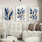 Three framed leaf prints above a beige sofa in a living room setting.