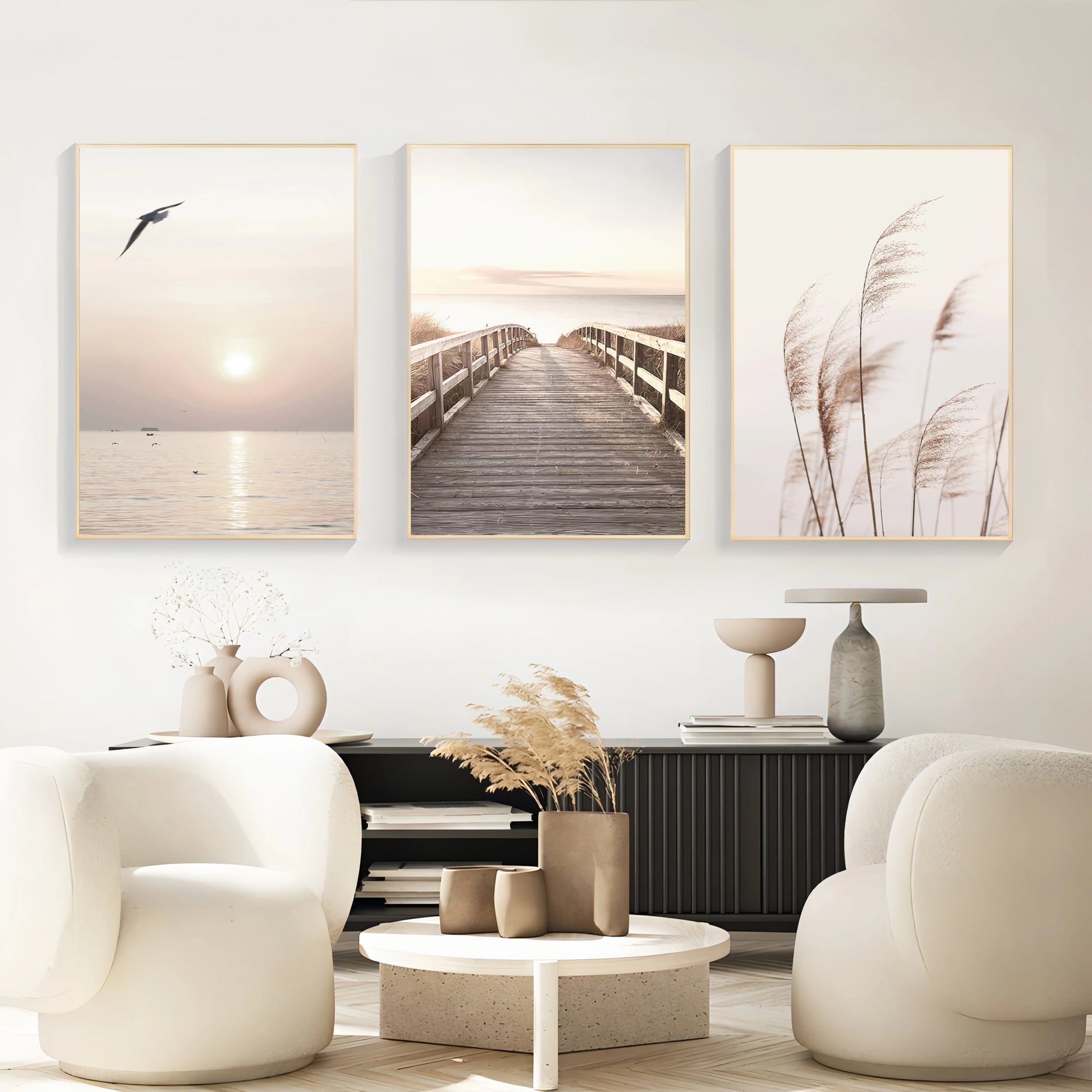 Modern living room with three framed artworks on the wall, white chairs, and a coffee table.