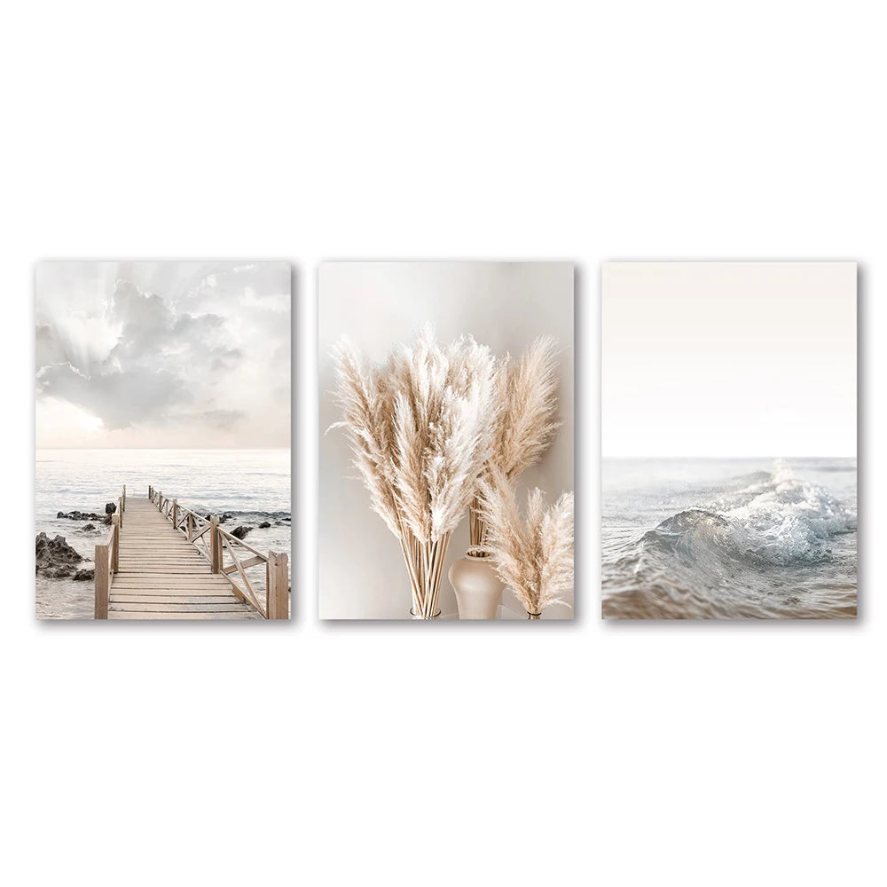 Set of three wall art pieces featuring a beach scene, dried plants, and ocean waves.