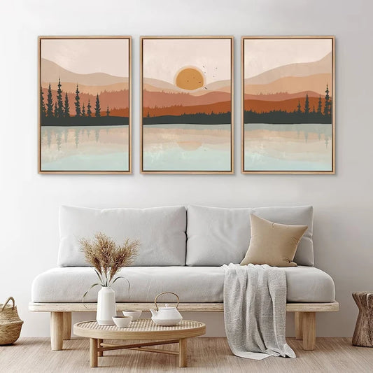 Living room with a white sofa, wooden coffee table, and three framed landscape artworks on the wall.