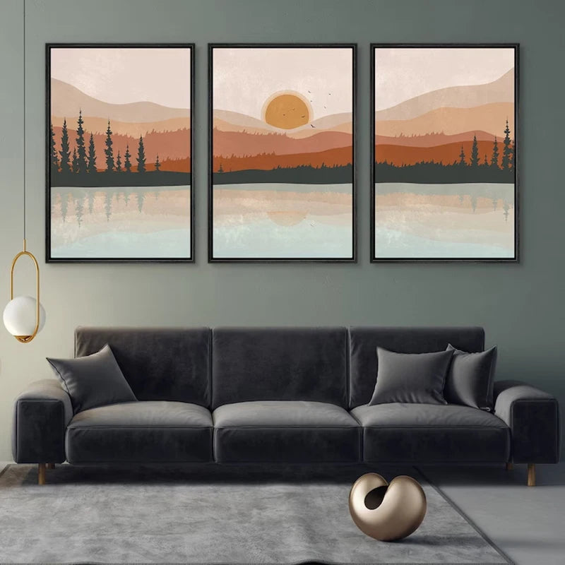 Three framed landscape paintings above a gray sofa in a living room.