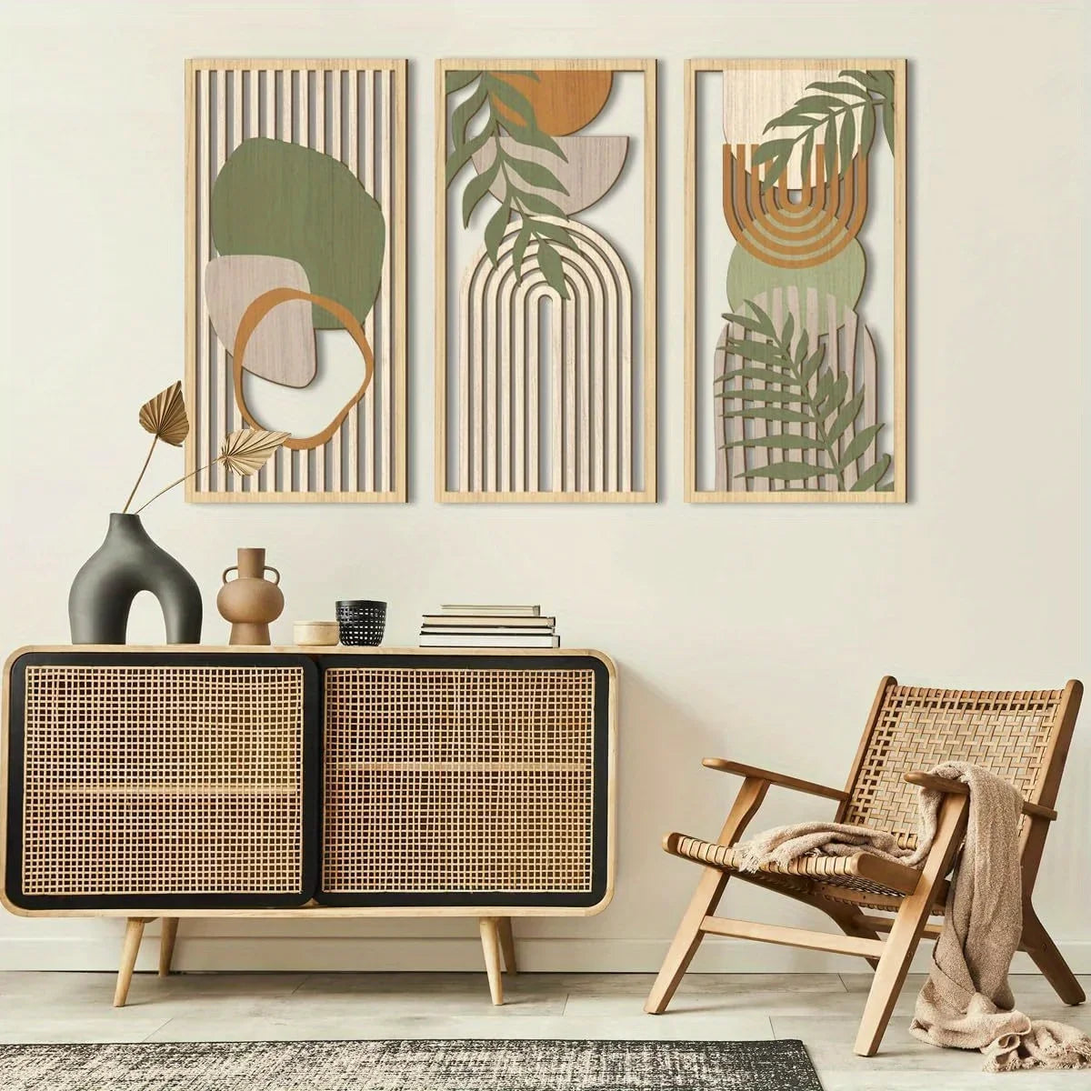 Decorative wall art with abstract plant designs above a wicker chair and cabinet.