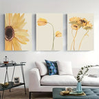 Three floral paintings above a white sofa in a living room.