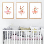 Three framed illustrations of a ballerina rabbit above a crib with decorative pillows.