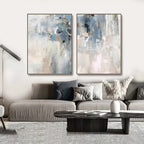 Two abstract paintings above a sofa in a living room setting.