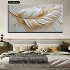 Decorative wall art of a gold feather on a textured background above a bed.