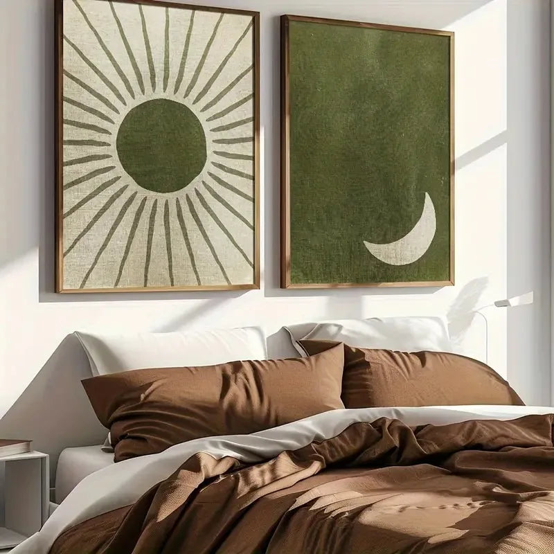 Two framed artworks on a wall above a bed with brown bedding.
