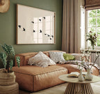 Cozy living room with a brown sofa, decorative pillows, and a framed artwork on a green wall.