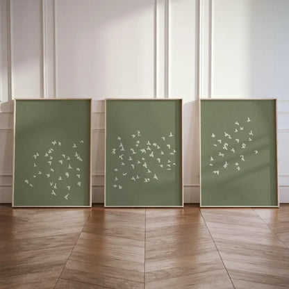 Three green panels with white abstract patterns on a wooden floor and light-colored wall background