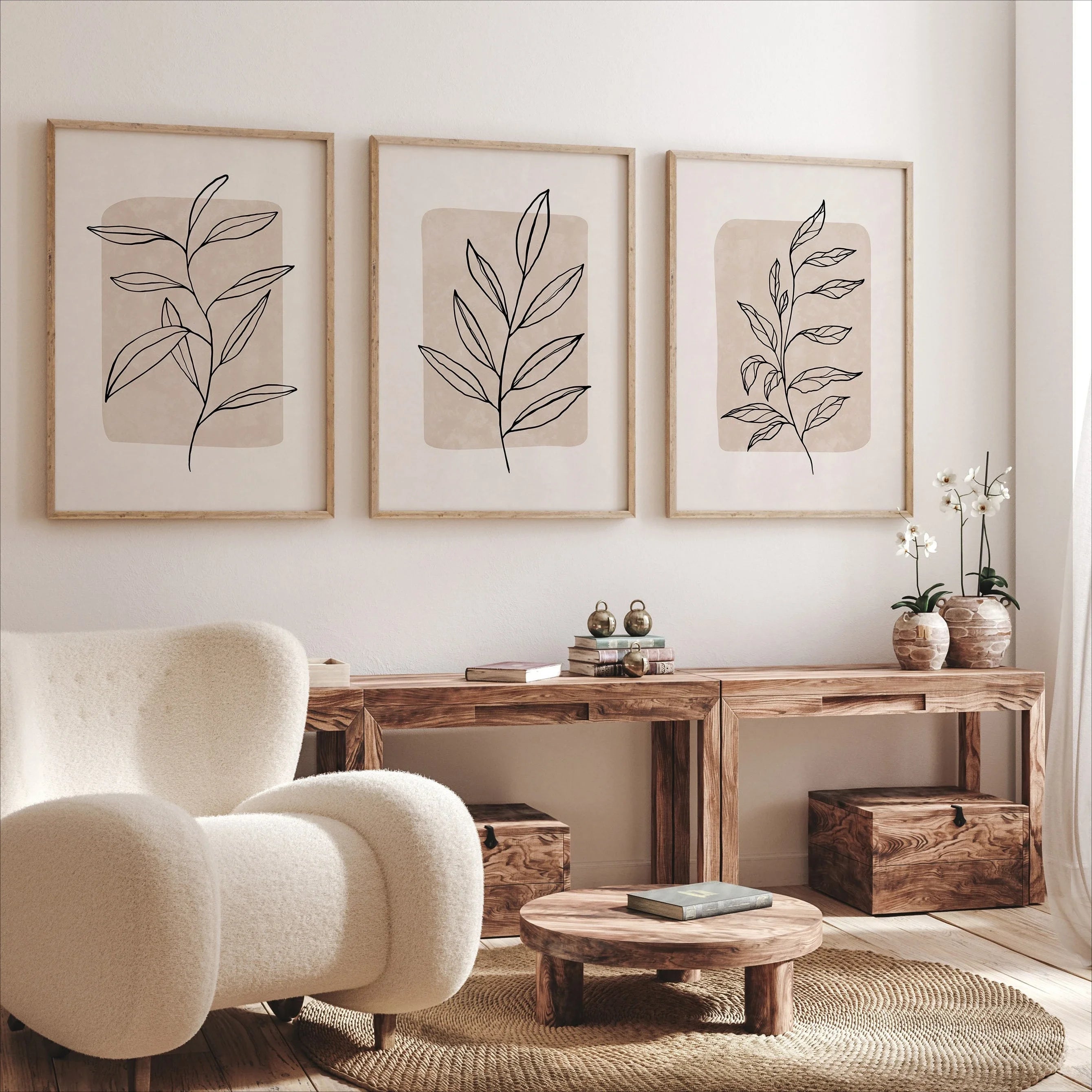 Living room with a beige armchair, wooden console table, and leaf-patterned wall art.