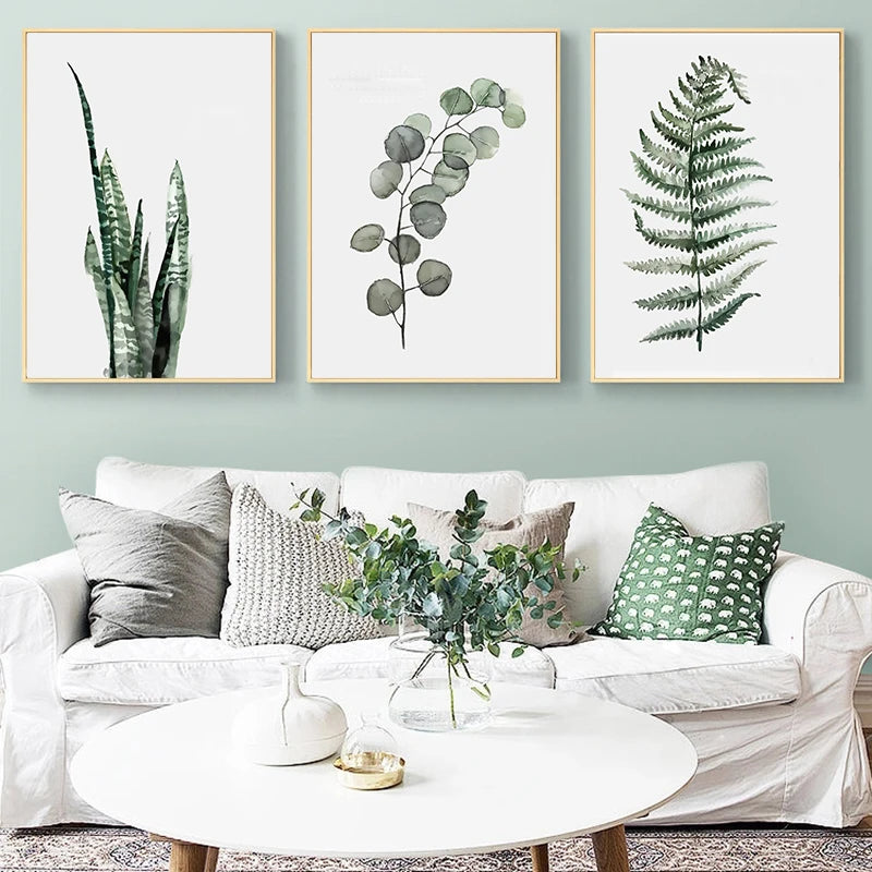 Living room with a white sofa, decorative pillows, and framed botanical prints on the wall.