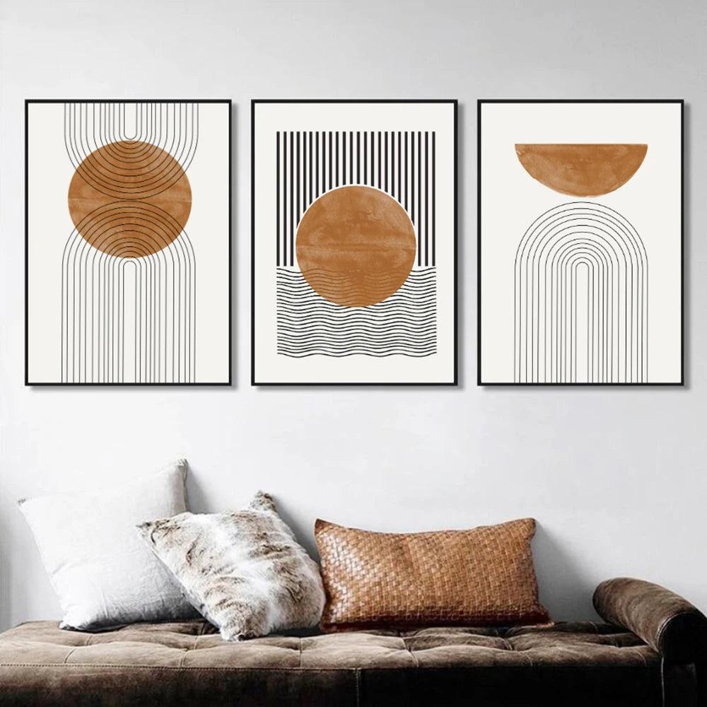 Three abstract art prints with geometric shapes on a wall above a sofa.