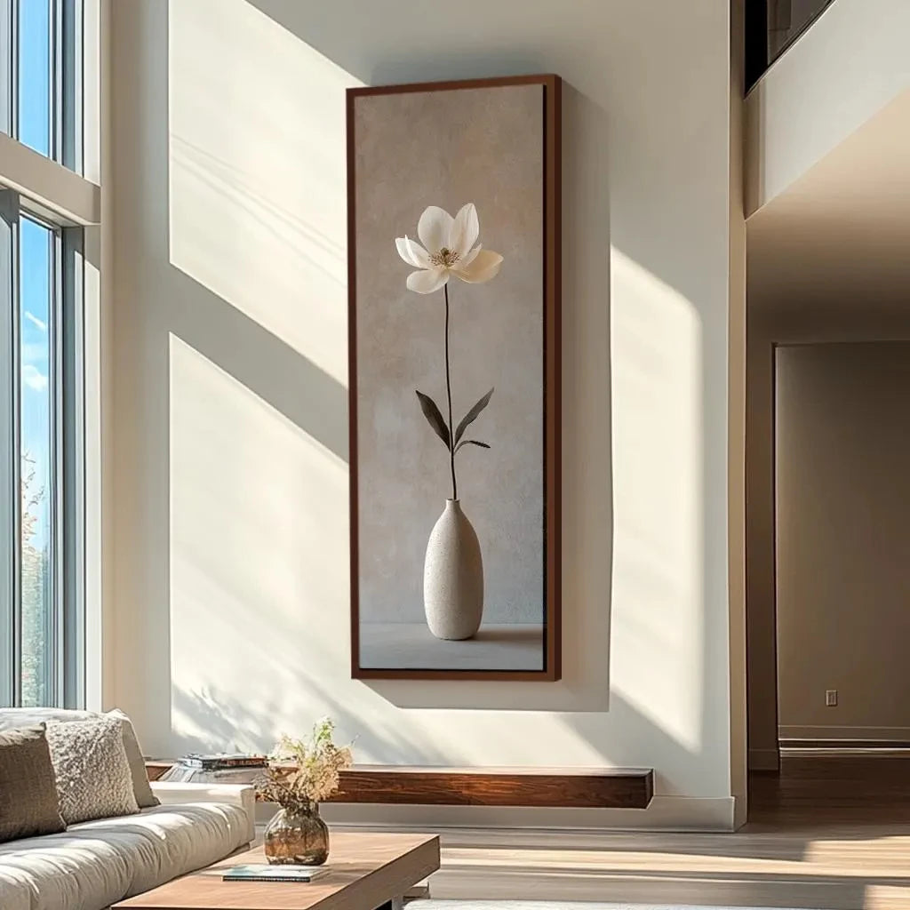 Framed artwork of a white flower in a vase on a wall in a modern living room.