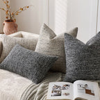 Textured throw pillows on a sofa with an open magazine underneath.