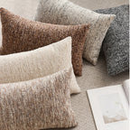 Textured throw pillows in various colors on a surface with a magazine.