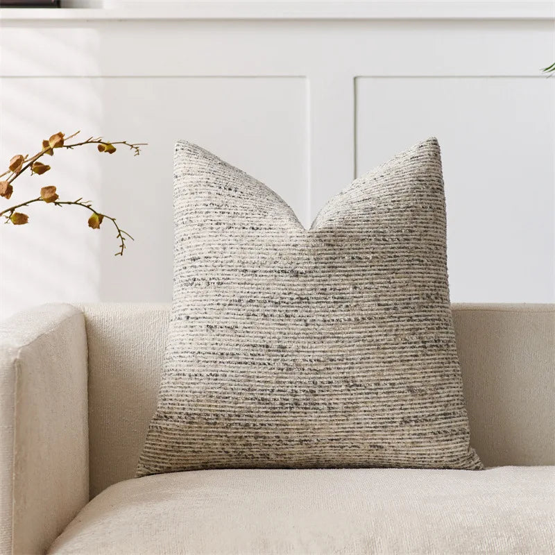 Textured throw pillow on a beige sofa with a neutral background