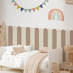 Children's bedroom with striped headboard, rainbow decoration, and colorful banner.