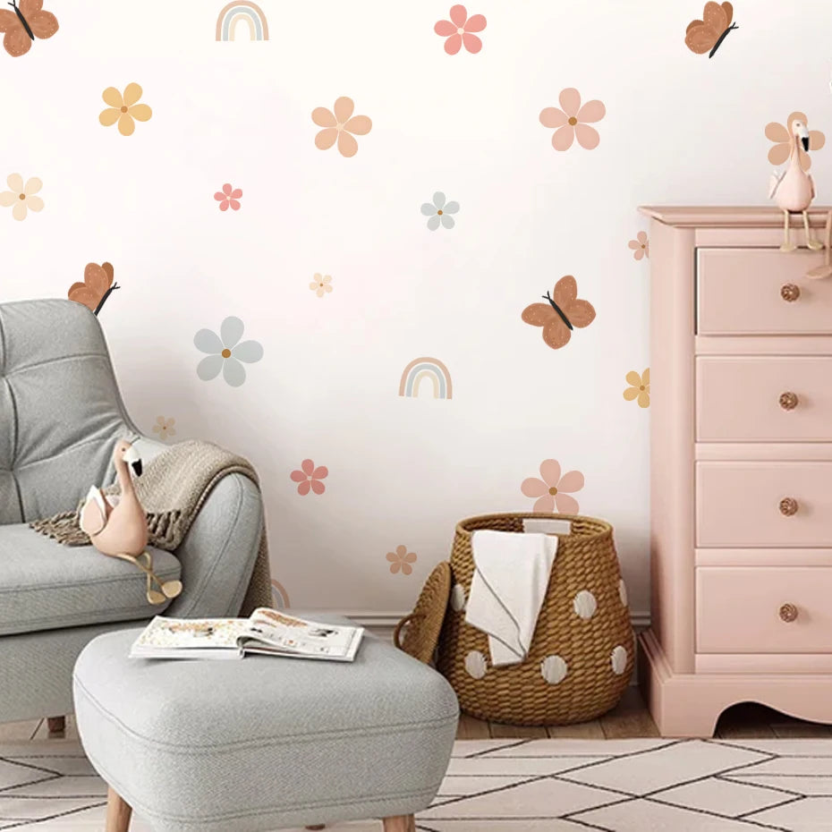 Children's room with floral wall decals, pink dresser, and gray chair.
