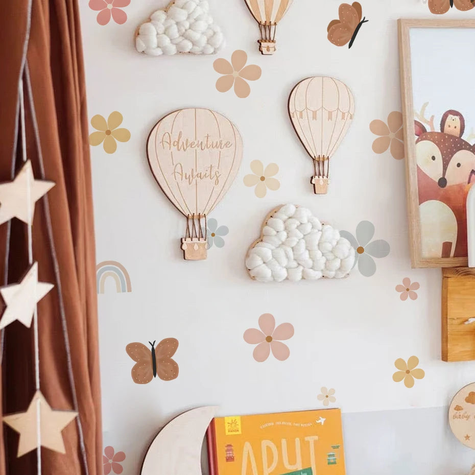 Children's room decor with hot air balloons, clouds, and animals on a wall.
