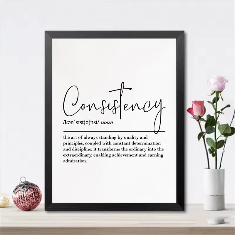 Framed print with the word 'Consistency' and its definition on a white wall with decorative elements.
