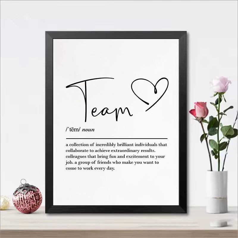 Framed print with the word 'Team' and its definition on a white wall with decorative items.