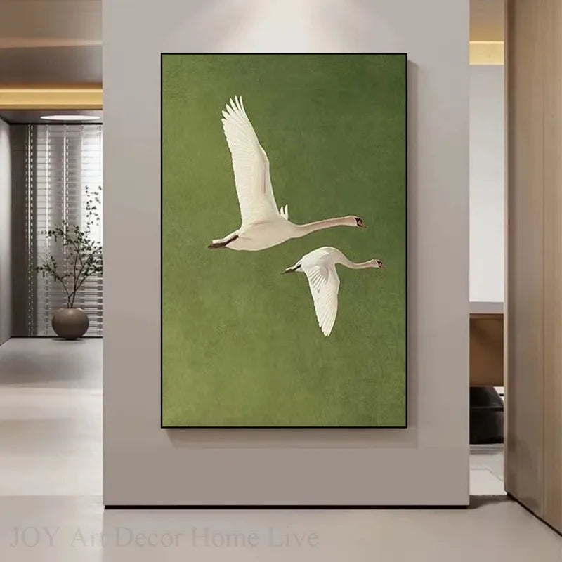 Framed artwork of two swans on a green background in a modern interior setting.