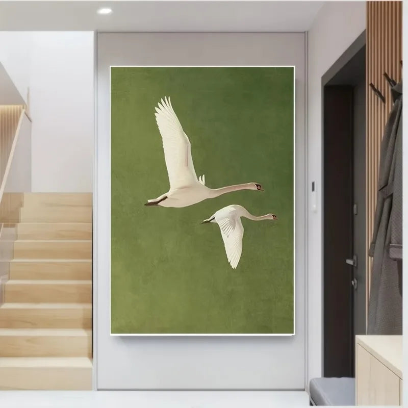 Framed artwork of two swans on a green background in a modern interior setting.