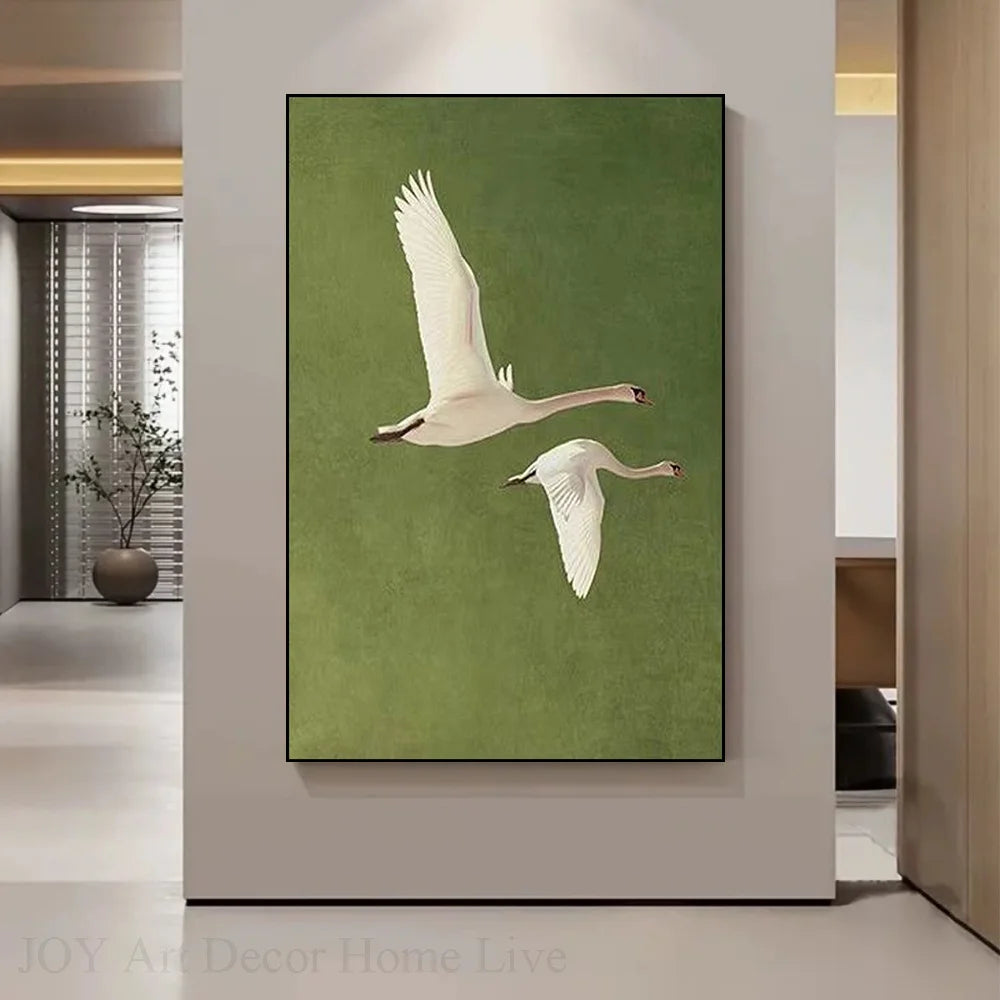 Framed artwork of two swans on a green background in a modern interior setting.