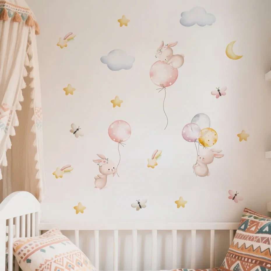 Children's room with decorative wall stickers of rabbits with balloons and stars on a white crib.