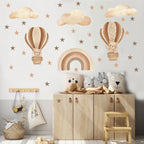 Children's room with wooden furniture, decorative pillows, and wall stickers of hot air balloons and rainbows.