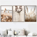 Three framed prints of nature scenes on a wall above a sofa.