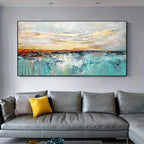 A large abstract canvas painting of a coastal sunset hangs on a light gray wall above a modern gray leather sectional sofa with a yellow accent pillow.