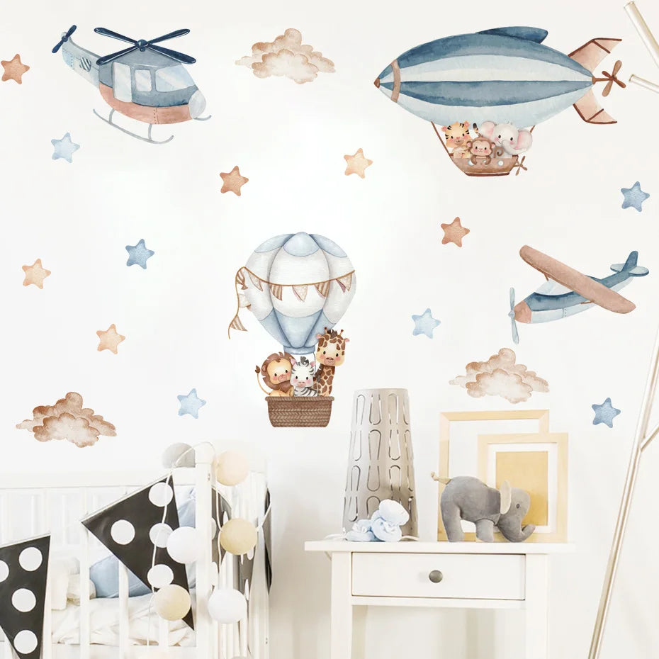 Children's room with wall stickers of airplanes, balloons, and animals on a white wall.