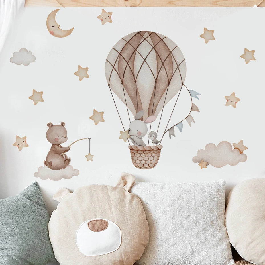 Children's room decor with a hot air balloon, teddy bear, and cloud patterns on a white background.