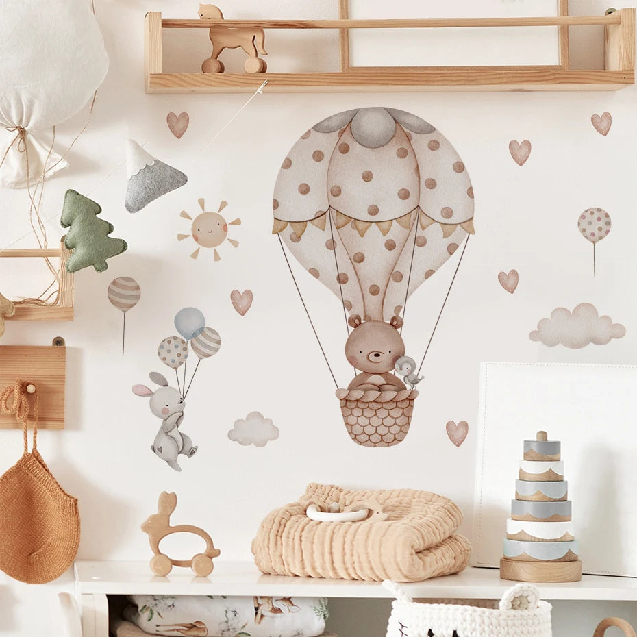 Nursery room with wall decals of a teddy bear in a hot air balloon, balloons, and clouds.