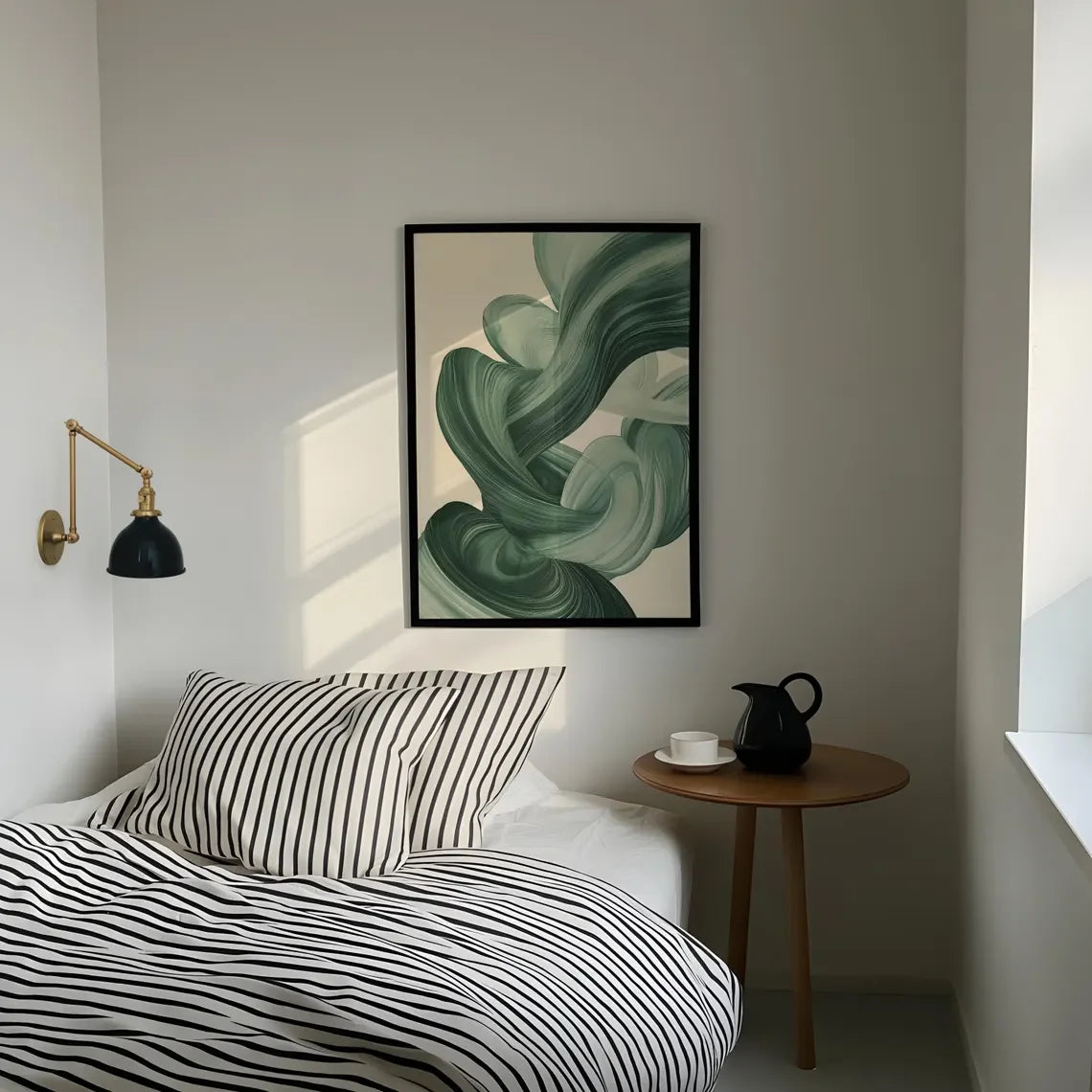 Modern bedroom with abstract green artwork on the wall, striped bedding, and a side table.