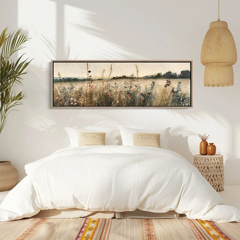 Bedroom with white bedding, framed artwork of a field, and decorative elements.