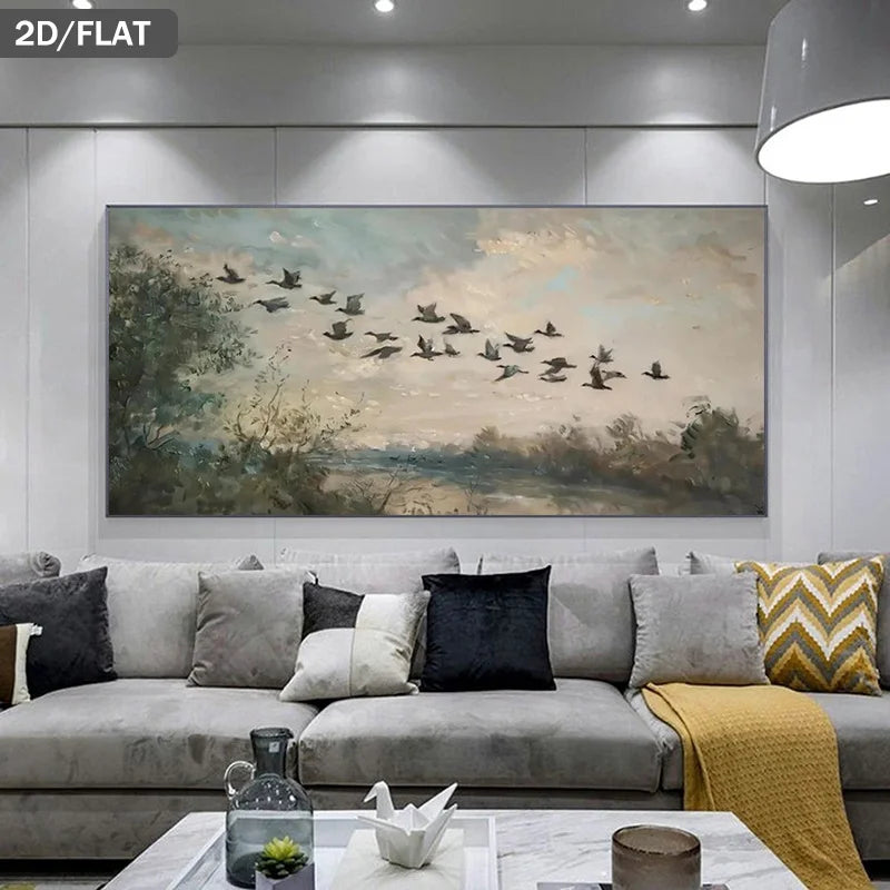 A large rectangular wall art print showing a flock of birds flying over a misty landscape, displayed above a gray sofa in a modern living room setting.