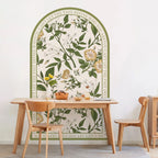 Dining area with a table and chairs in front of a decorative wall mural with floral and botanical design.