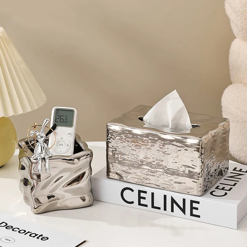 Decorative tissue box with a marble texture on a surface with a 'Celine' book.