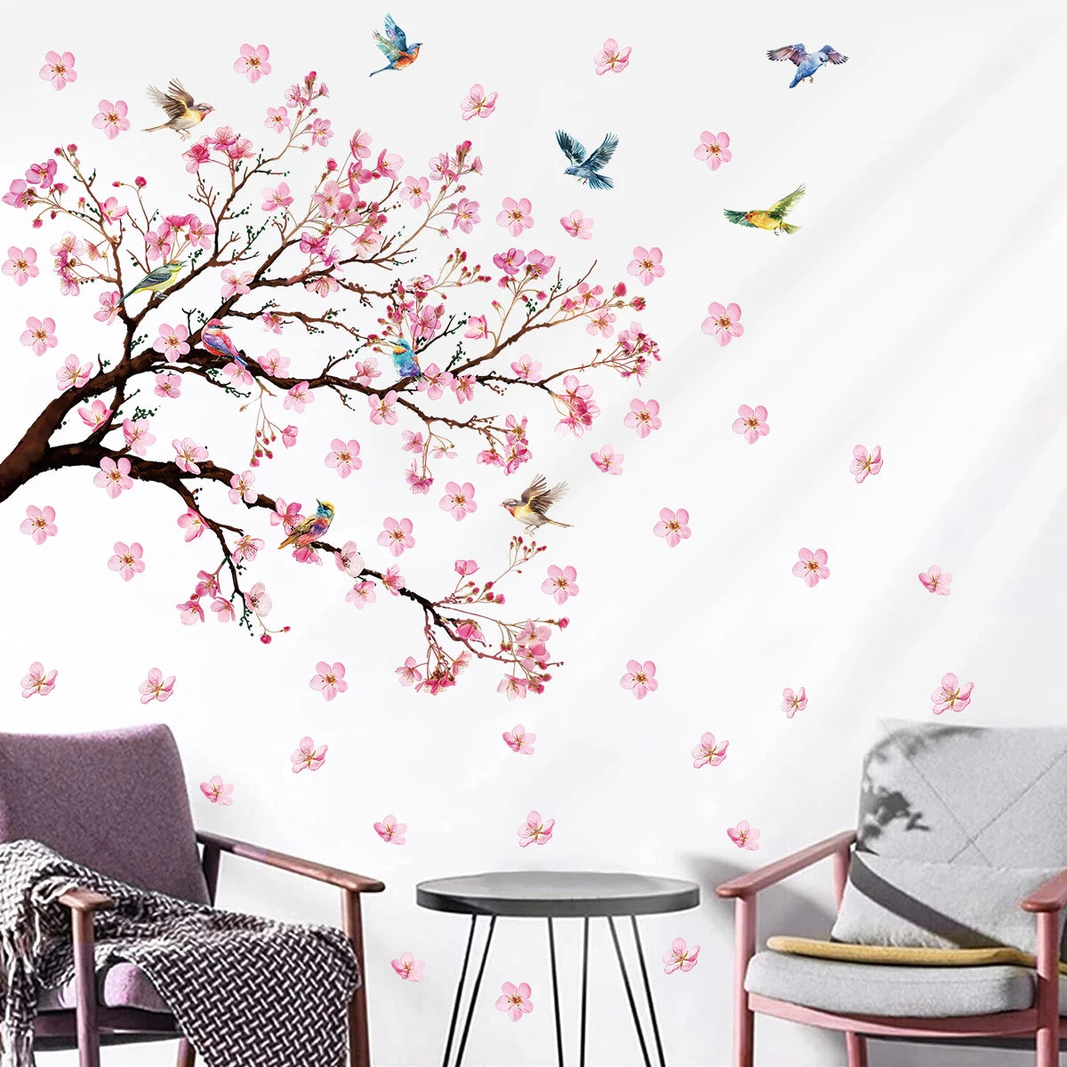 Wall decal of cherry blossom tree with pink flowers and birds on a white wall.