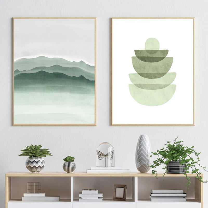 Two framed green abstract artworks on a wall with a shelf below displaying decorative items.
