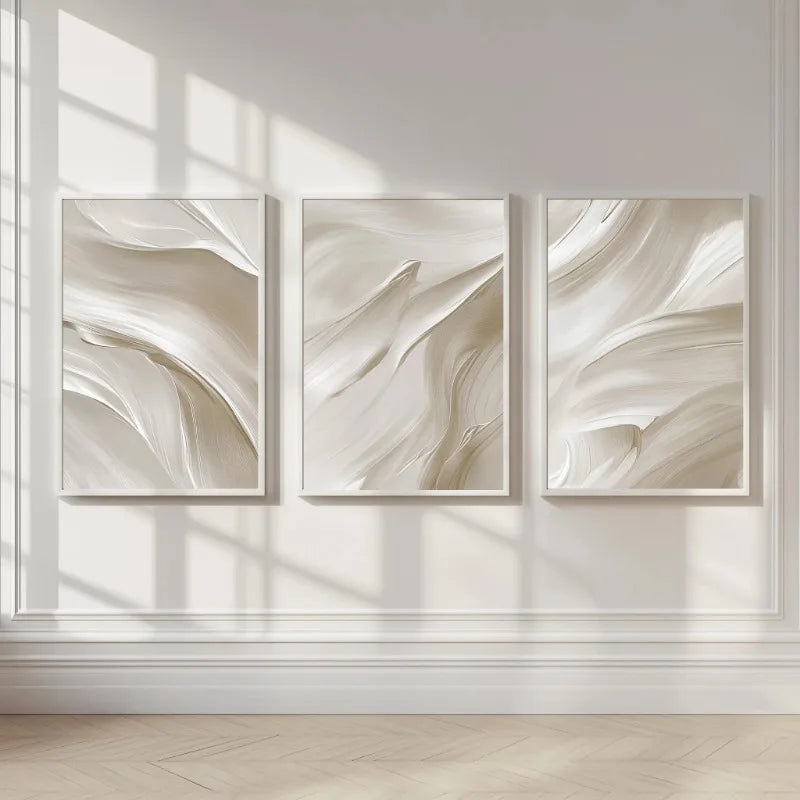 Three abstract wall art pieces in neutral tones on a light wall.