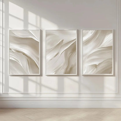 Three abstract wall art pieces in neutral tones on a light wall.