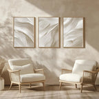 Two wooden chairs with white cushions in a room with abstract wall art.
