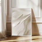 Abstract art print in a white frame on a wall with soft lighting