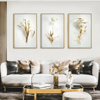 Modern living room with a white sofa, decorative pillows, and framed floral art on the wall.