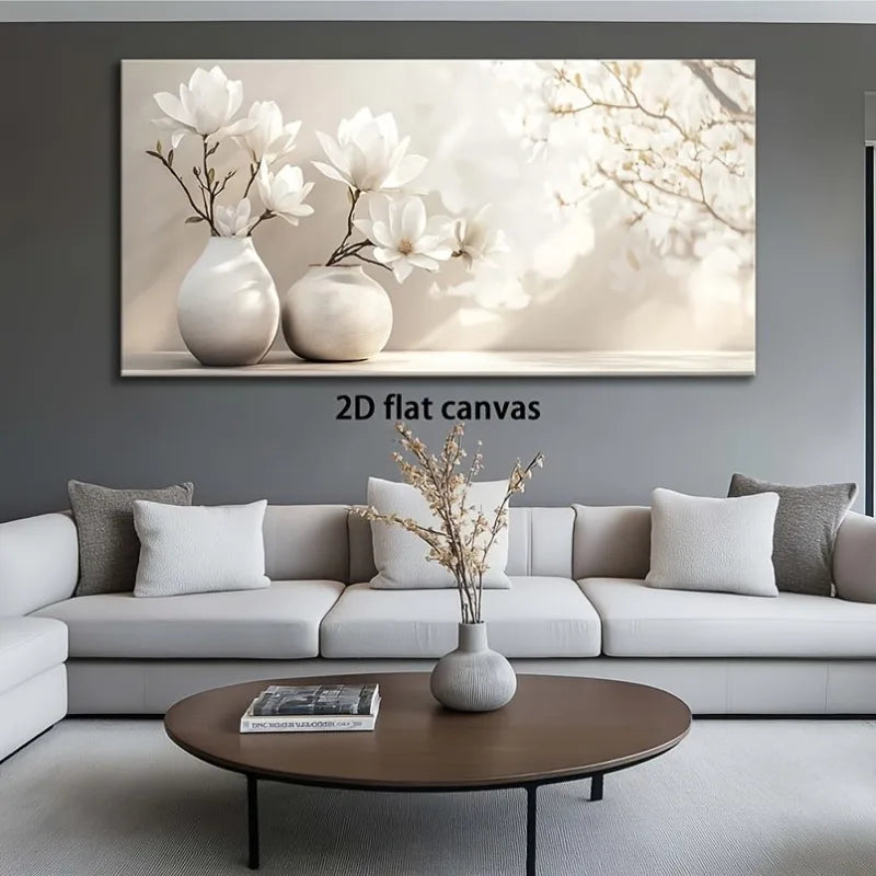 A large rectangular wall art canvas showing white magnolia flowers in two cream vases against a soft beige and white background, displayed above a light gray sectional sofa in a modern living room. The text '2D flat canvas' appears below the artwork.