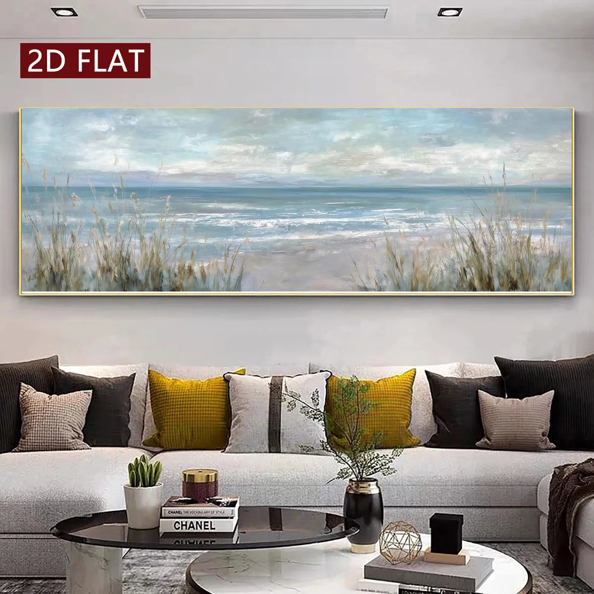 A large panoramic wall art print depicting a calm blue ocean and cloudy sky with beach grasses in the foreground, displayed above a modern sofa in a styled living room. A red label in the top-left corner reads '2D FLAT'.